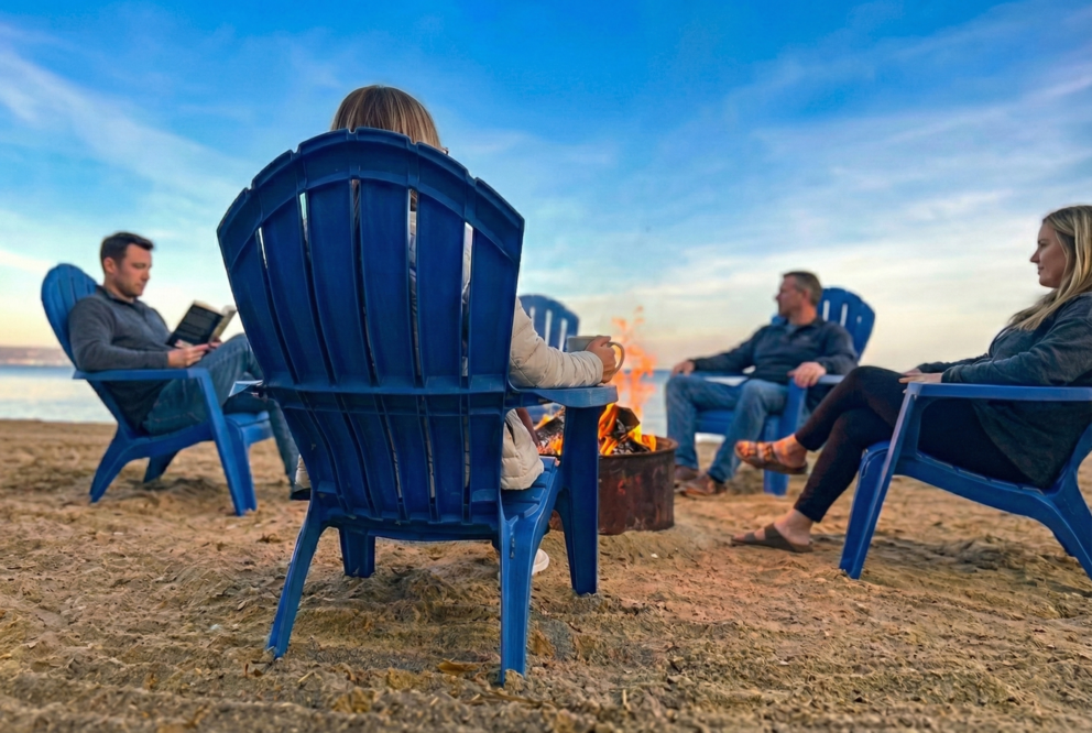 a group of people sitting in chairs around a fire