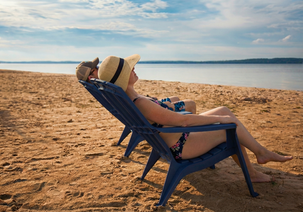 a man and woman sitting in a chair on a beach